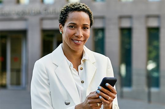 Woman smiling while holding a mobile phone 